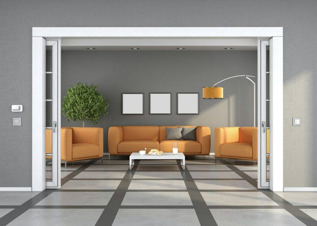 Sliding door in living room with sofa and orange armchairs in the background